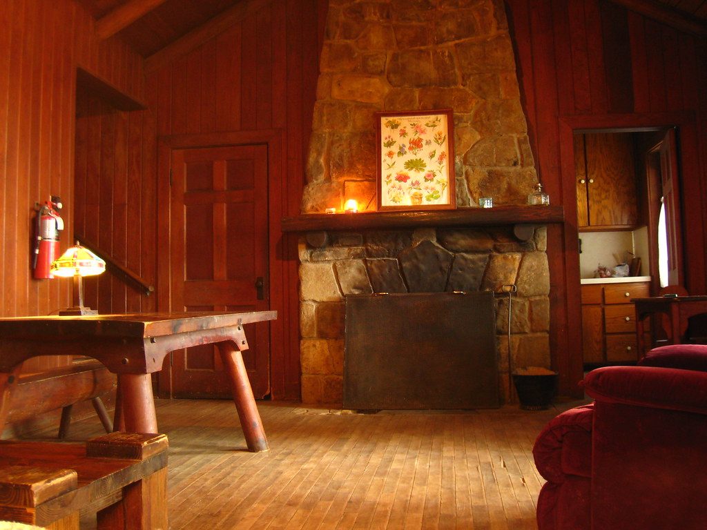 Salón de la casa con chimenea de piedra encendida